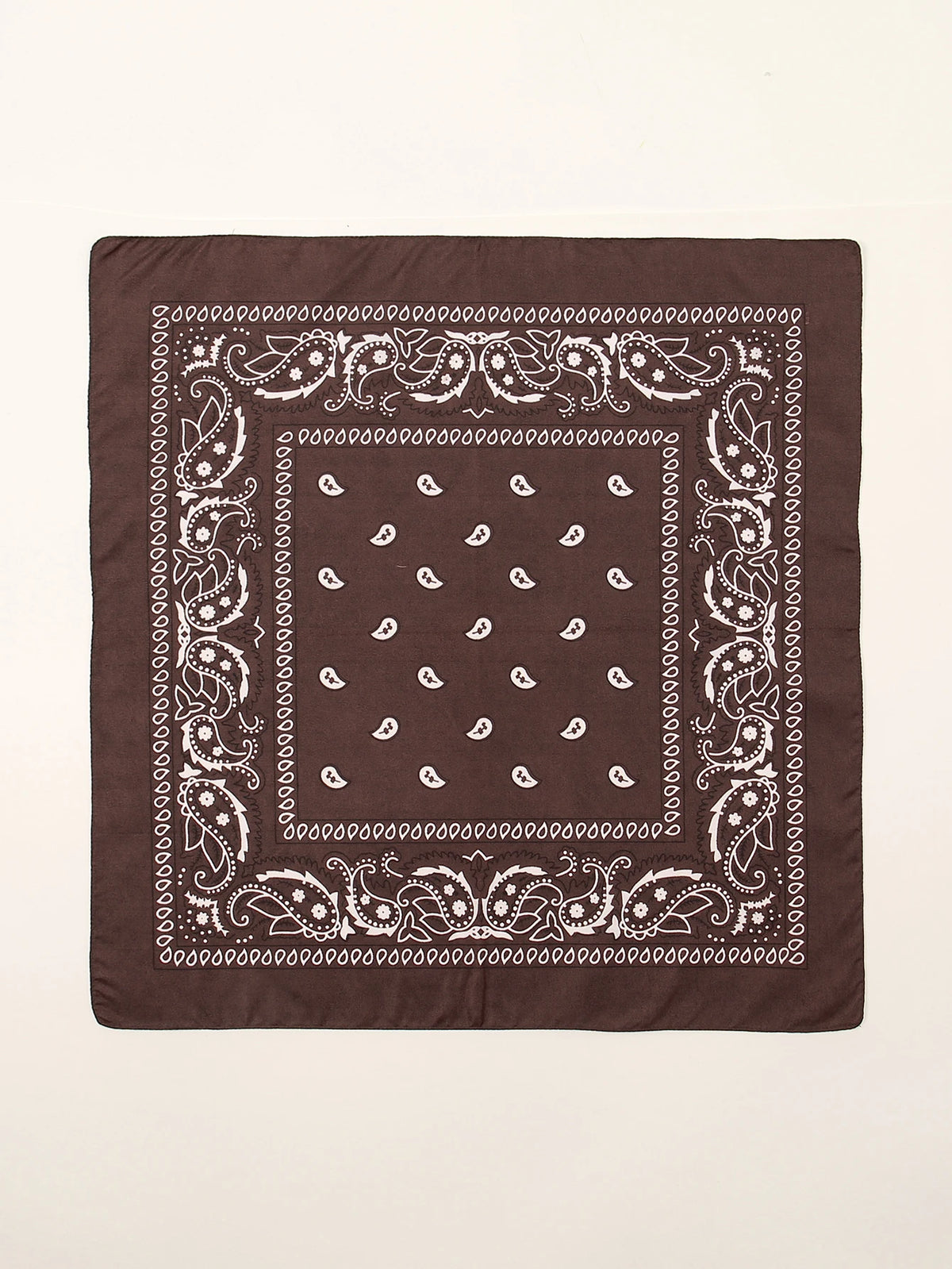 Tissu brun foncé carré avec motifs paisley blancs et géométriques sur fond clair.