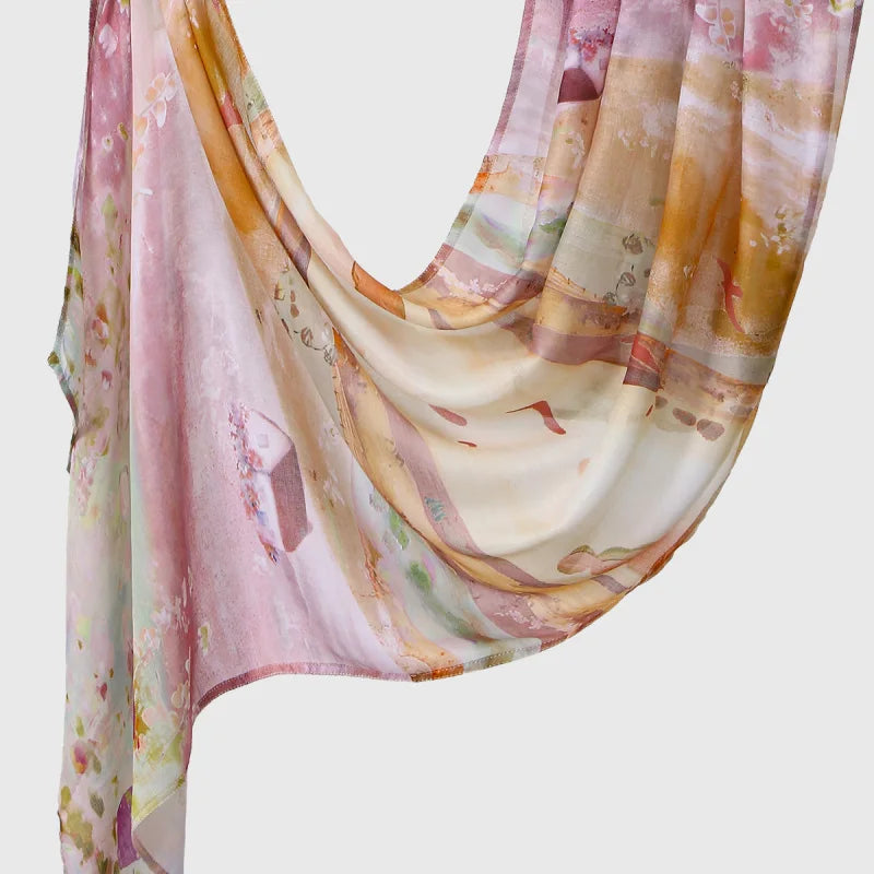 A flowing, sheer linen hijab scarf featuring soft pink and beige floral prints draped elegantly.