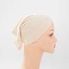 Beige Bambus-Jersey-Turban-Kappe auf einem Mannequin-Kopf.