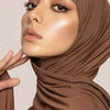 Nahaufnahme einer Frau, die einen einfarbigen braunen Modal-Baumwoll-Jersey-Hijab trägt