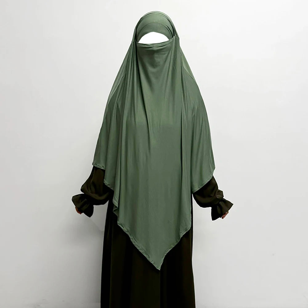 Smaragdgrüner atmungsaktiver Bambus-Jersey-Khimar-Hijab über einem dunklen Kleidungsstück.