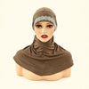 Una modelo lleva un gorro hijab marrón de cobertura total con adornos plateados y un dobladillo de tela a juego.