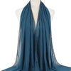 Ein tealfarbener Chiffon-Hijab-Schal, um den Hals einer Mannequin drapiert.