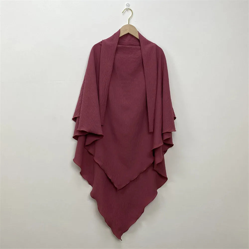 A deep magenta two-layer everyday hijab scarf draped on a wooden hanger against a white background.