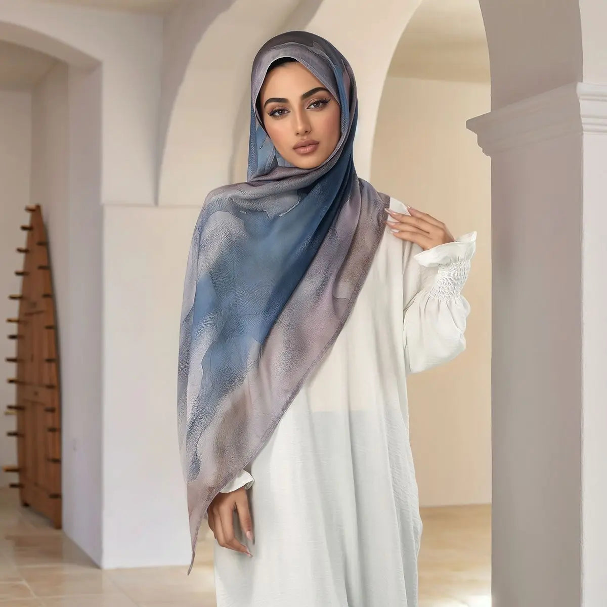 Eine Frau trägt einen blau-grauen Aquarell-digitalen Hijab und weißes Kleidung.