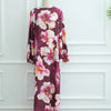 Langes dunkelrotes Abaya-Kleid mit Blumenmuster aus rosa und weißen Pfingstrosen auf einem Mannequin.