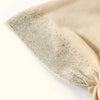 Beige Baumwoll-Elastband-Cap mit silbernen Glitzerverzierungen.