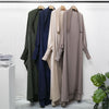 Eine Kollektion langer, fließender, dezenter Abayas in gedämpften Farben wie Olivgrün, Marineblau und Beige.