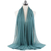 A teal chiffon hijab scarf draped around a mannequin neck.