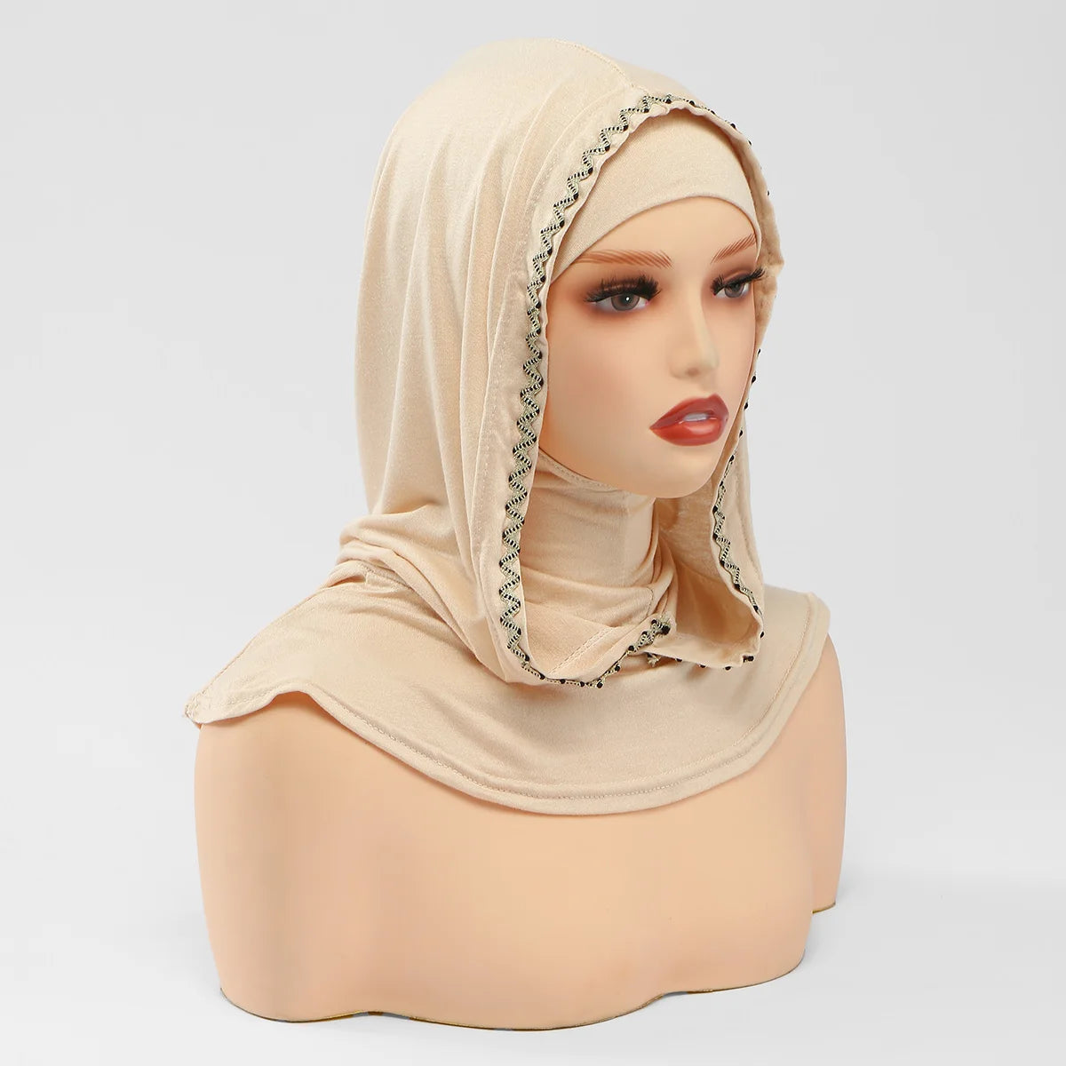 Un modèle porte un bonnet hijab beige à double couche instantané avec une bordure décorative.