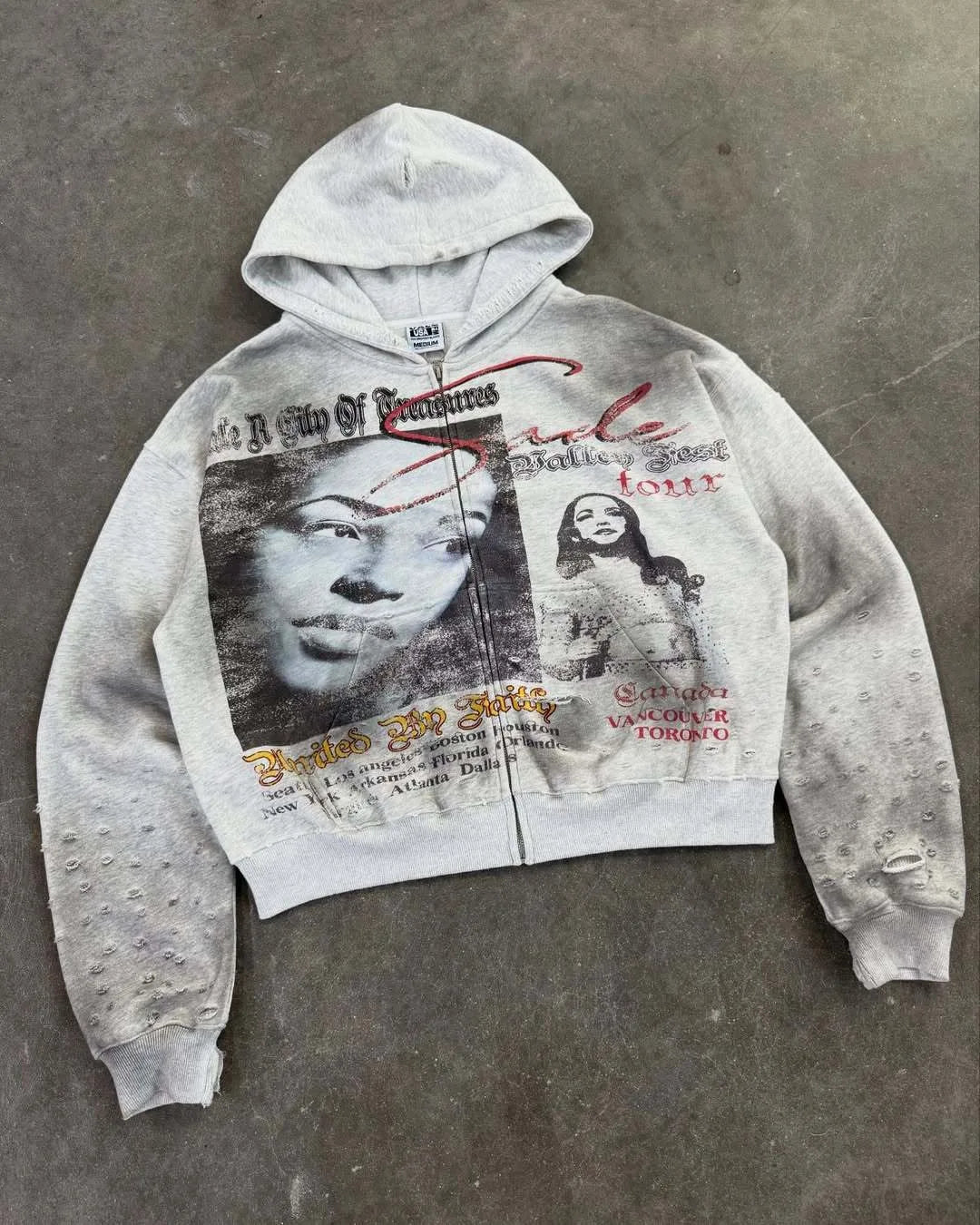 Helle graue Kapuzenjacke mit Vintage-Text und fotografischen Elementen auf der Vorderseite.