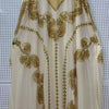 Cremefarbener Batwing-Robe-Kleid mit aufwendiger goldener Paillettenstickerei und Details.