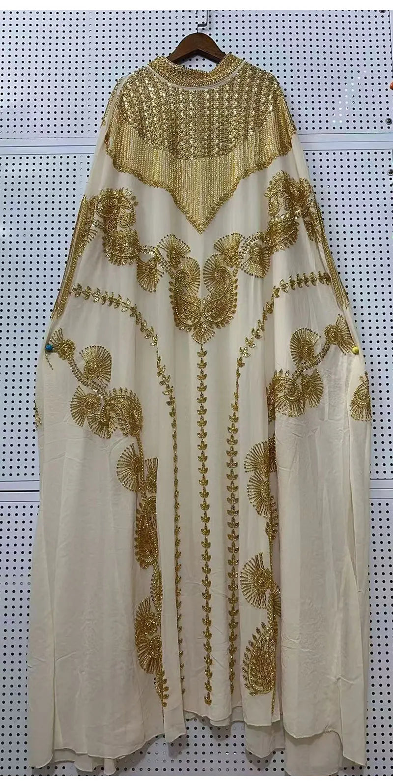 Cremefarbener Batwing-Robe-Kleid mit aufwendiger goldener Paillettenstickerei und Details.