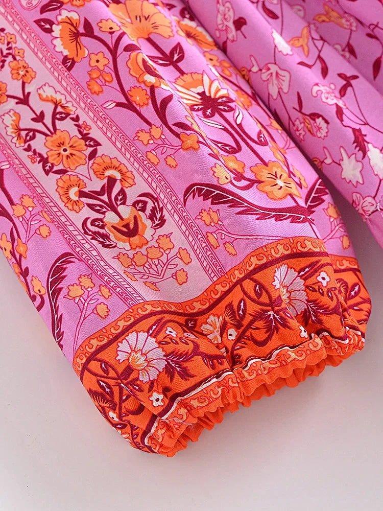 Pink fabric with orange floral print showing a gathered cuff detail on a dress sleeve.