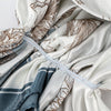 A close-up of a white satin floral print instant turban hijab being wrapped.