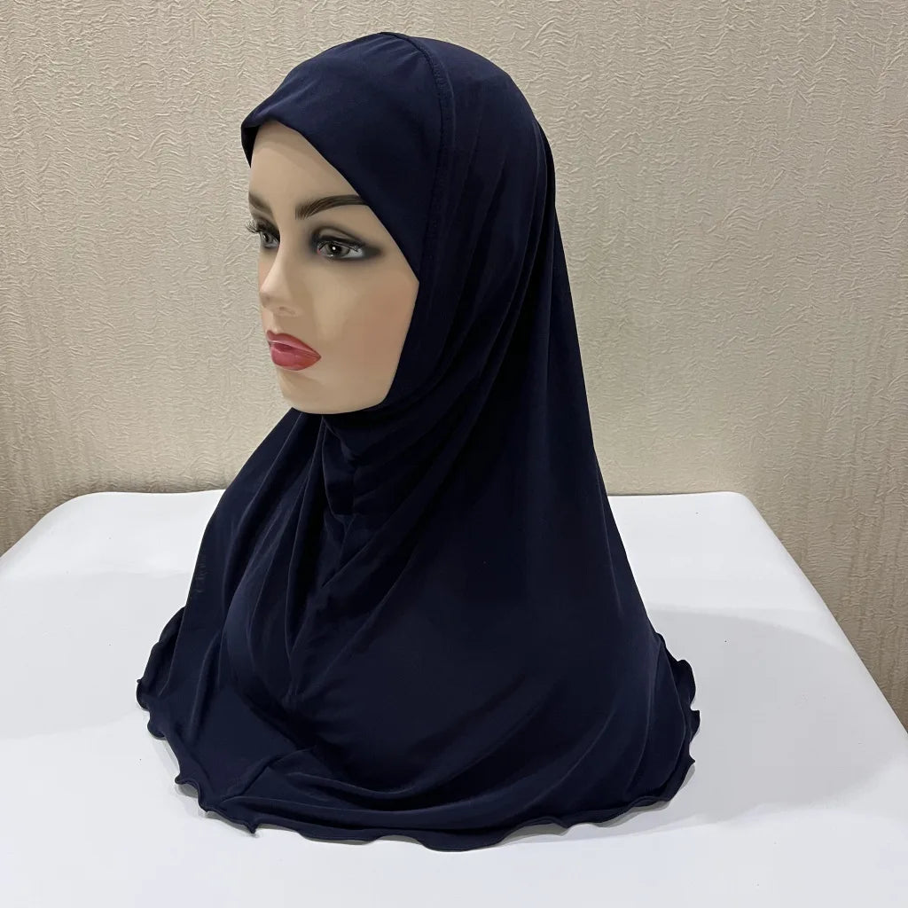 Un chal de hijab azul marino oscuro para niños colgado sobre un maniquí.
