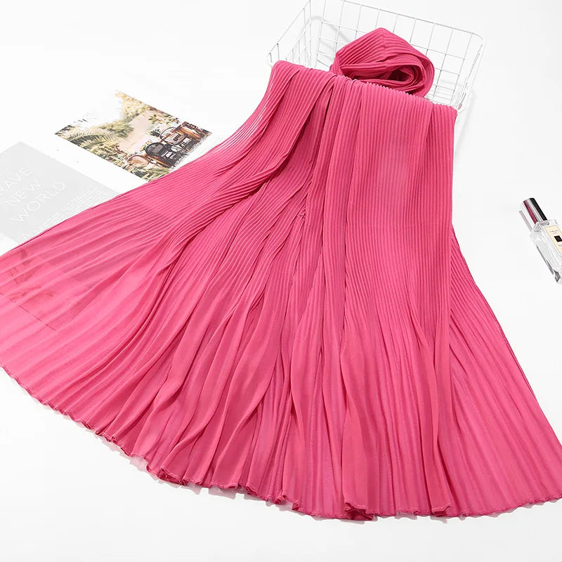 Leuchtend pinkes Crinkle-Chiffon-Hijab-Schal, drapiert und gefaltet auf einem Drahtrost.