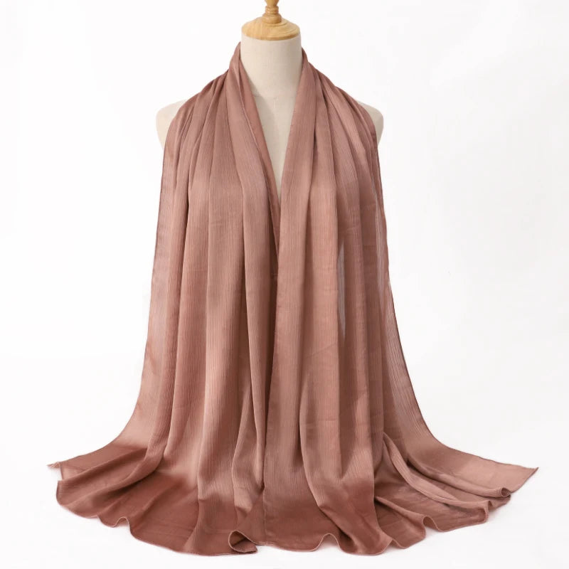 Ein drapierter, staubrosa Satin-Krinkle-Hijab-Schal auf einem Mannequin.