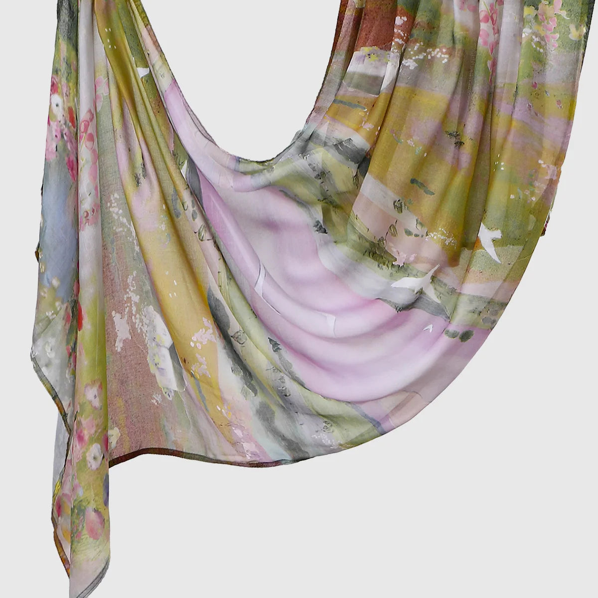 A flowing, sheer linen hijab scarf featuring a watercolor print of pink, green, and yellow tones.