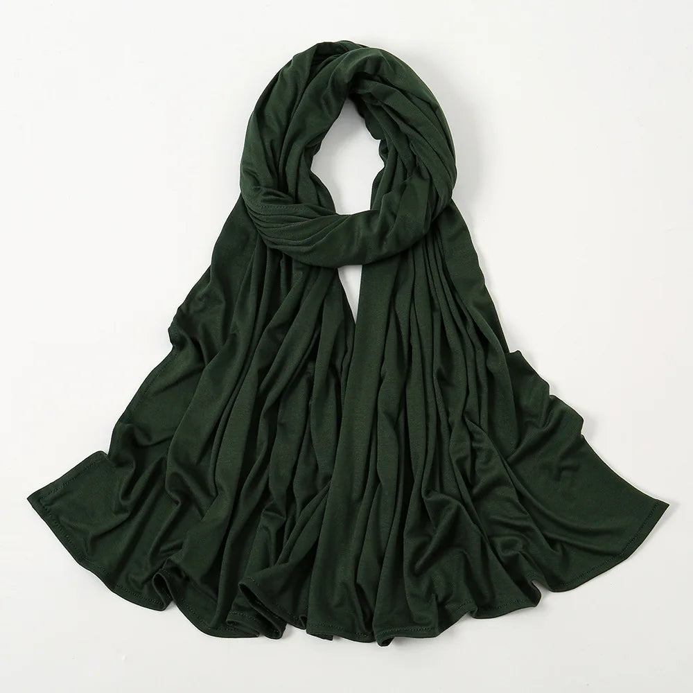 Dunkelgrüner Tuchschal, drapiert und gefaltet, auf weißem Hintergrund.