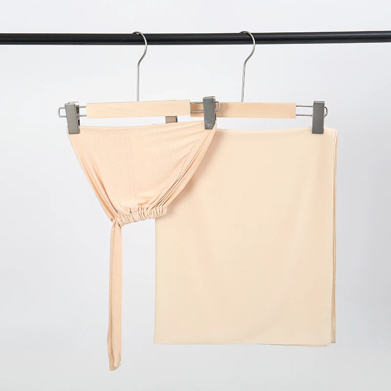 Helles beige Chiffon-Hijab und Untercap-Set an einem schwarzen Stäbchen aufgehängt.