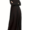 Une femme portant une longue robe maxi ample noire à col montant et manches longues.
