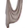 Foulard hijab en mousseline beige doux avec bordour de faux cils, drapé verticalement.