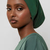 Model wearing a deep emerald green bamboo jersey tube hijab cap.