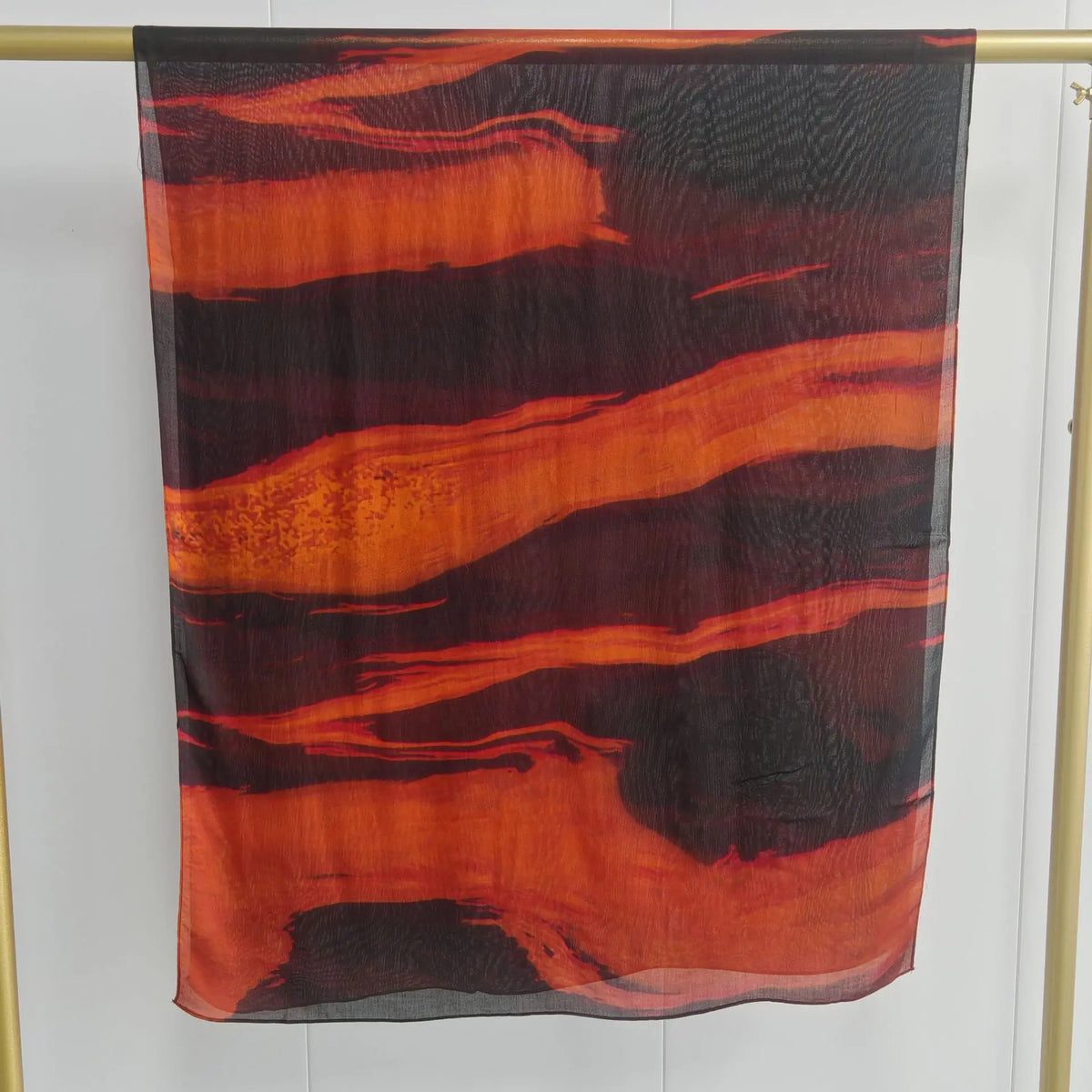 Dunkler, durchscheinender Schal mit abstrakten, gewellten Streifen in Orange und Schwarz.