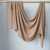 Écharpe de hijab couleur beige unie drapée sur un cintre en bois.