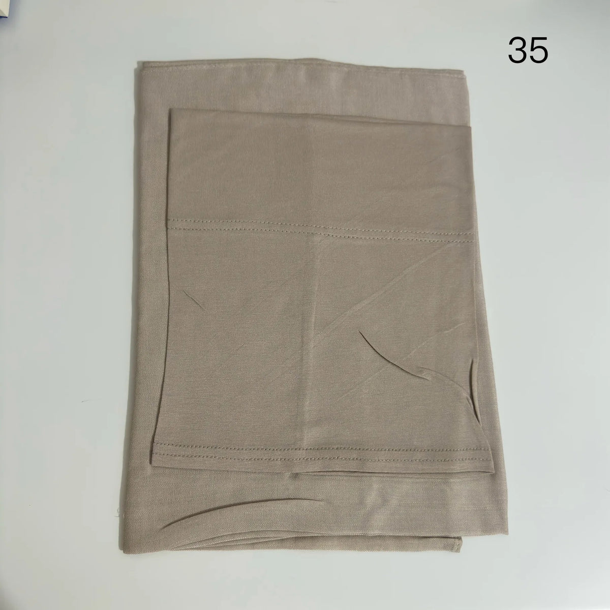 A beige soft modal rayon hijab set displayed flat, showing the fabric and stitching details.
