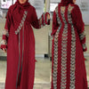 Una mujer modela un abaya granate con bordados plateados y mangas largas.