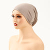 Model wearing a beige stretch jersey inner hijab cap on her head.