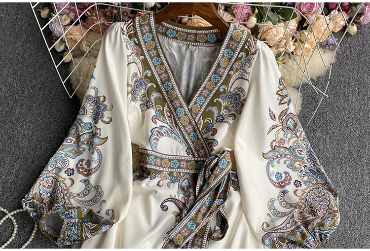 Weißes Blumen-Spitzen-Maxikleid mit aufwendiger Stickerei und V-Ausschnitt auf einem Bügel.