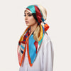 A woman wearing an elegant satin silk instant hijab scarf with multicolored stripes over a white shirt.