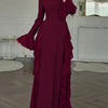 A maroon long-sleeve maxi dress with ruffled details displayed on a model.