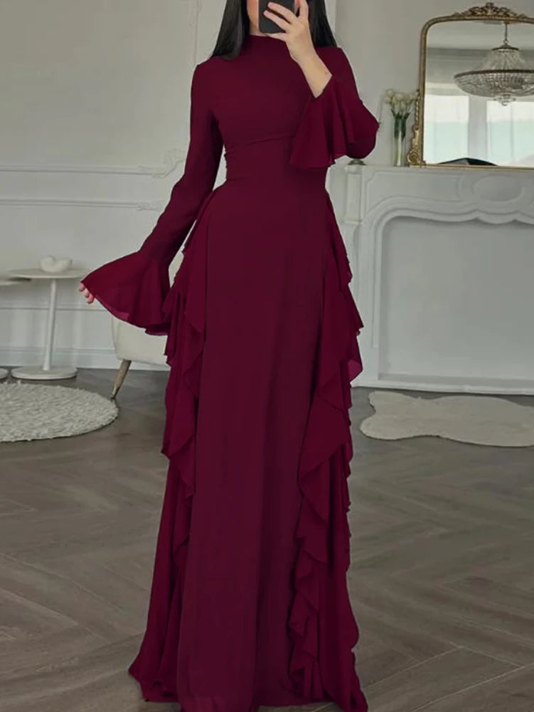 A maroon long-sleeve maxi dress with ruffled details displayed on a model.