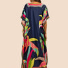 Eine Frau modelliert ein dunkelblaues marokkanisches Batwing Kaftan-Überkleid mit farbigem Blumenmuster.