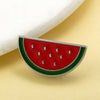 Rotes Wassermelonen-Emaliepenn-Anstecknadel mit grüner Schale und silberner Umrandung auf hellem gelbem Untergrund.