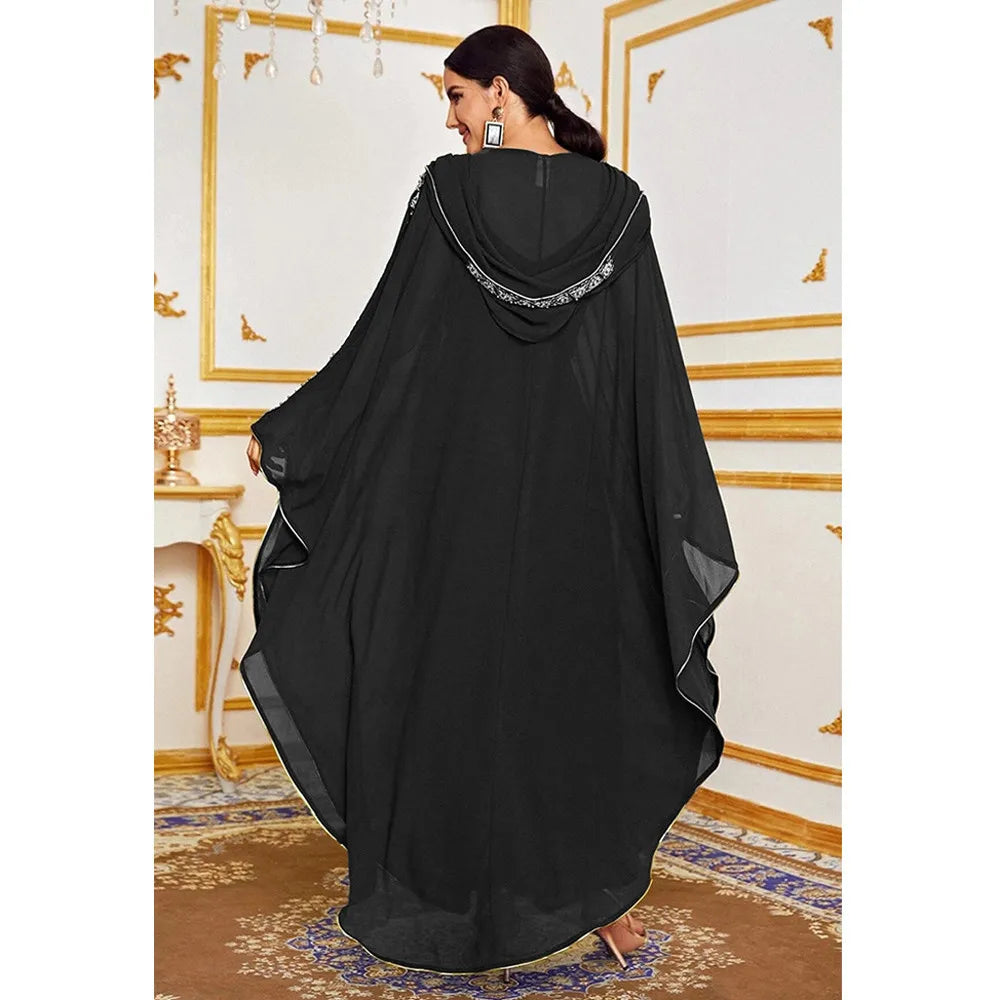 Un vestido maxi abaya negro y fluído con mangas de murciélago mostrado en una modelo.