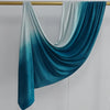Pañuelo de algodón hijab degradado en verde azulado y azul drapeado sobre un percha dorada.