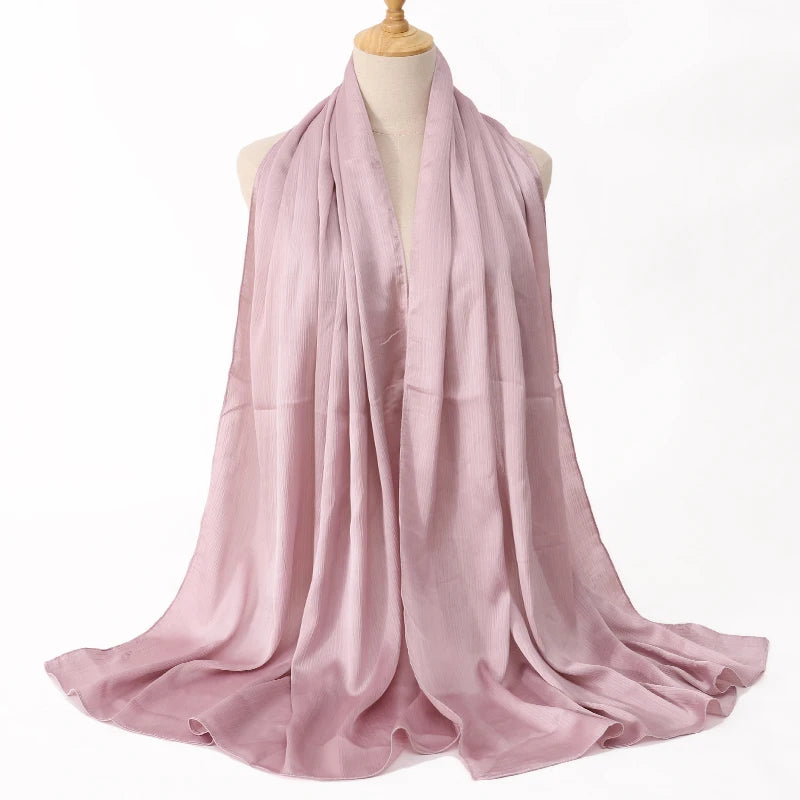 Weicher rosa Satin-Crinkle-Hijab-Schal über einem Mannequin drapiert.