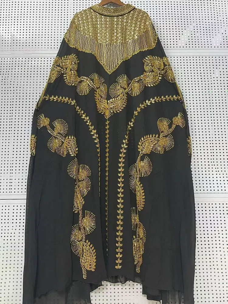 Schwarzes Batwing-Robe-Kleid mit schwerer goldener Paillettenstickerei und Fransenverzierung.