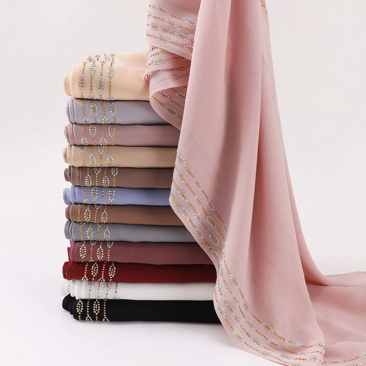 Una pila de pañuelos de chifón con pedrería rosa y beige para mujeres.
