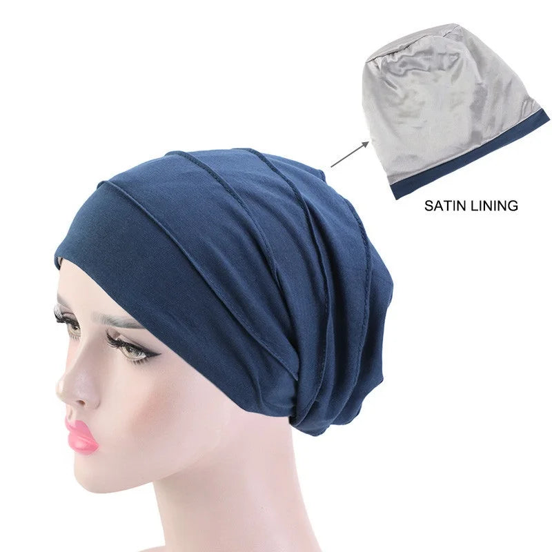 Dunkelblaue Stretch-Baumwollturbanmütze mit Satinfutter auf einem Mannequin-Kopf.