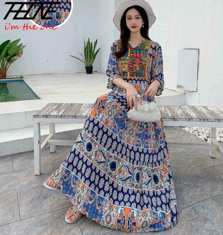 Eine Frau modelliert ein blau-orangees, bohémieninspiriertes, besticktes Maxi-Kleid im Freien.