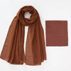 A flowing, rust-colored chiffon hijab and matching undercap set displayed flat.
