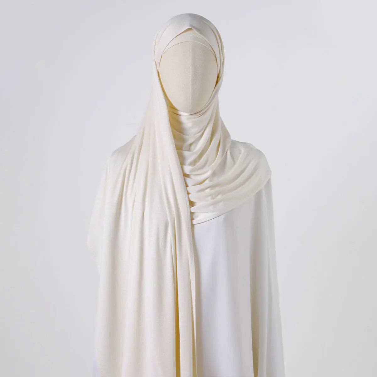Eine Mannequin präsentiert einen eleganten, einfarbigen Chiffon-Schal über einem weißen Kleidungsstück.