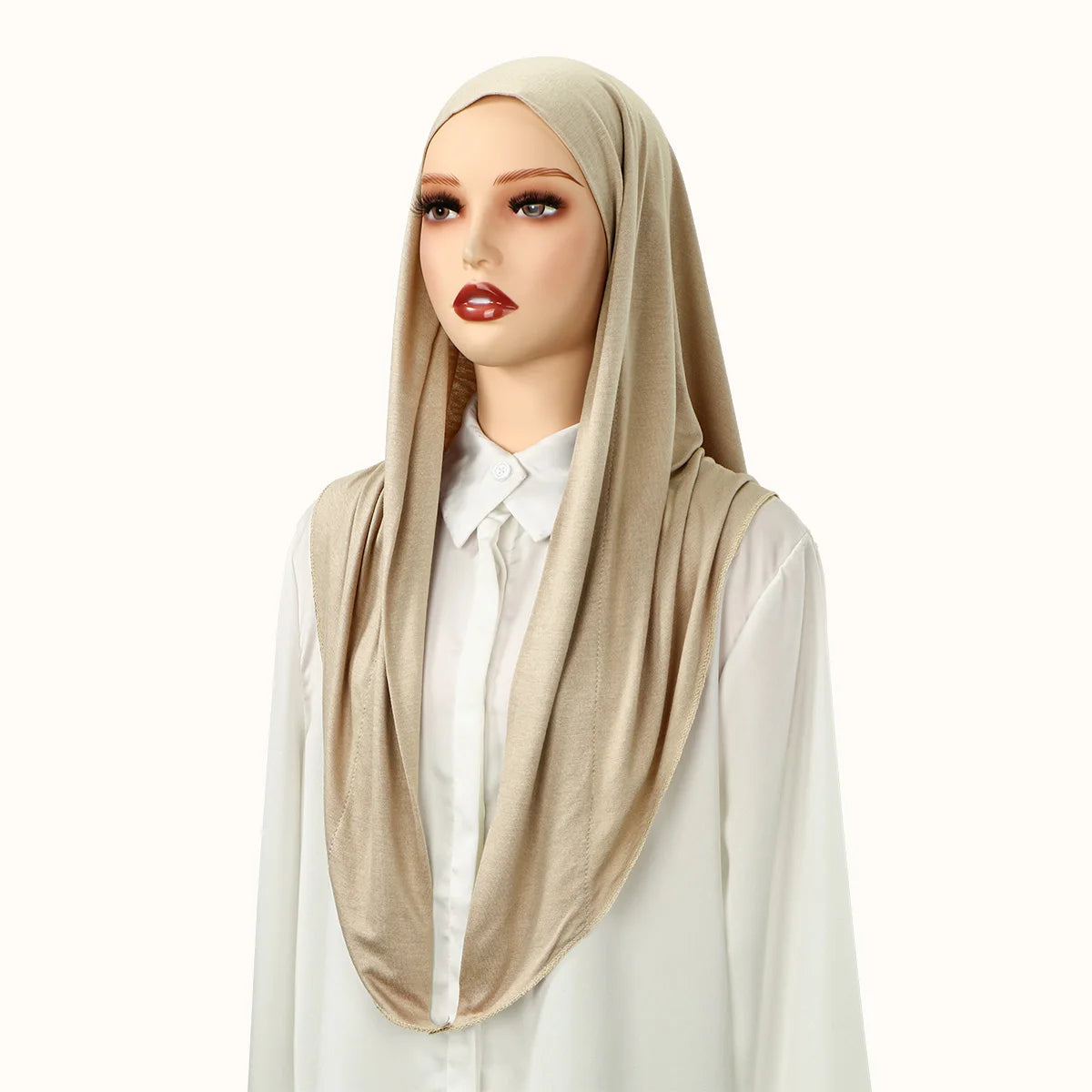 Eine Frau modelliert einen beigeen Jersey-Hijabschal über Kopf und Schultern, kombiniert mit einem weißen Oberteil.