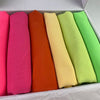 Eine Box mit sechs gerollten Chiffon-Hijab-Schals in Rosa-, Orange-, Gelb- und Grüntönen.